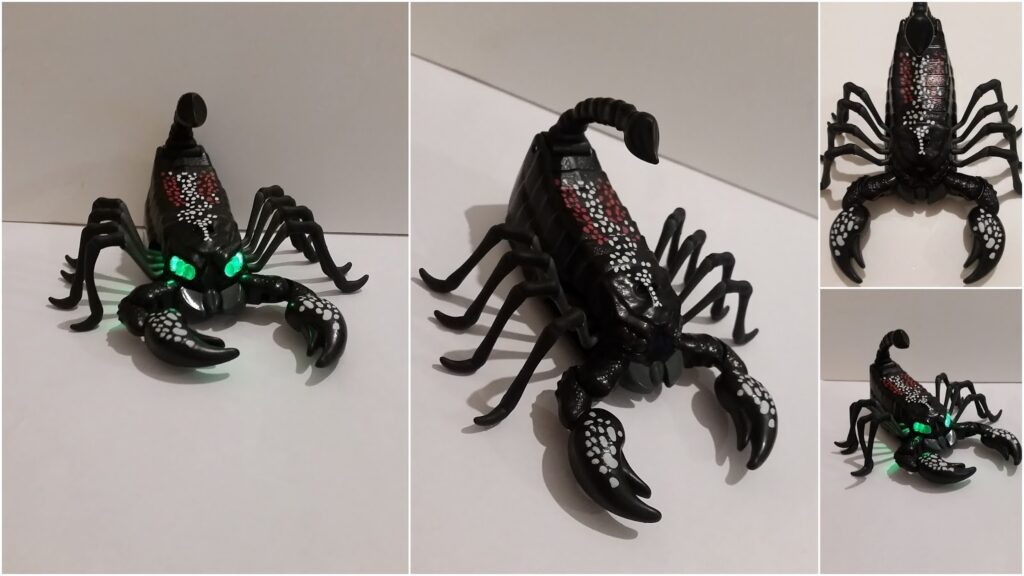 A black plastic toy scorpion with glowing green eyes, white and red dots on its back, large pincers, and curled tail, shown from multiple angles against a plain white background.