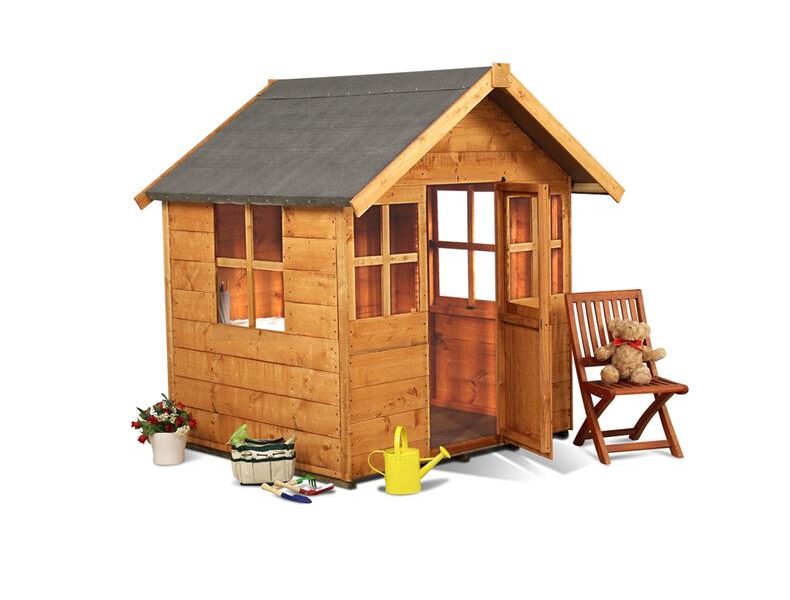 A small wooden playhouse with windows and an open door sits on a white background. Nearby are a wooden chair with a teddy bear, a yellow watering can, toy gardening tools, potted flowers, and a basket, suggesting a playful, garden-themed setting.