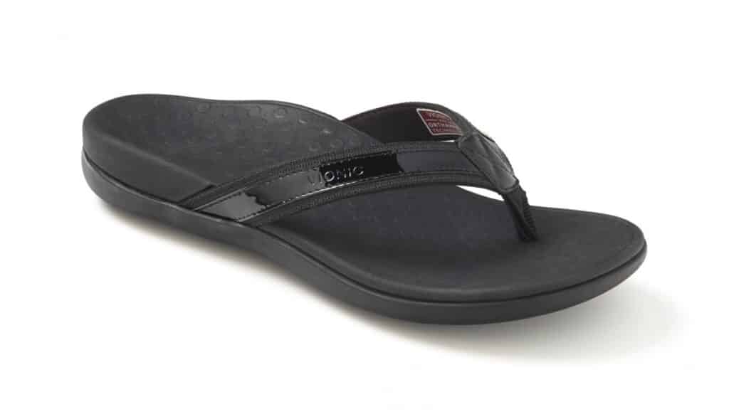 A single black flip-flop sandal with a textured footbed, shiny black straps, and a small label near the toe post. The sandal is angled to the left on a plain white background.