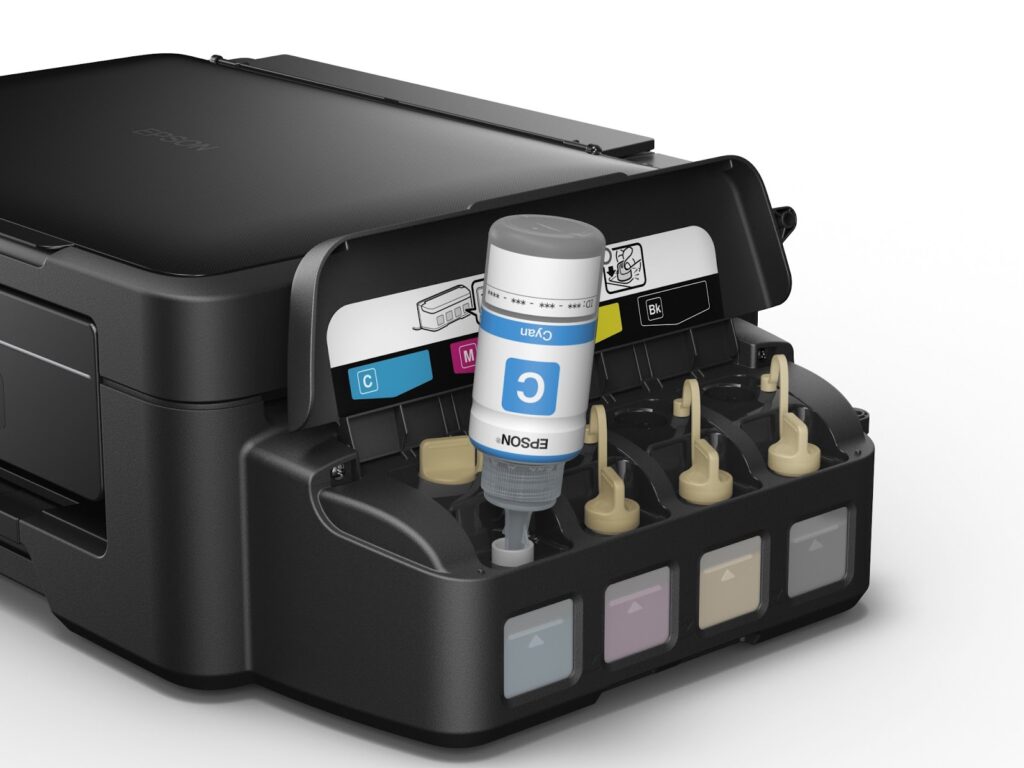A close-up of an Epson inkjet printer shows a cyan ink refill bottle being inserted into the cyan tank. Four refillable ink tanks, labelled C, M, Y, and K, are visible, with yellow, magenta, and black tanks covered by beige caps.