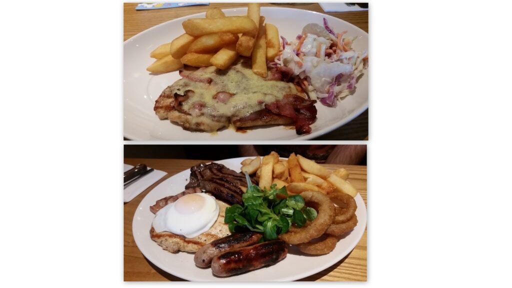 Two plates of food: The top plate has thick chips, coleslaw, and a piece of chicken topped with melted cheese and bacon. The bottom plate has chips, onion rings, sausage, steak, a fried egg, leafy greens, and a tomato slice.