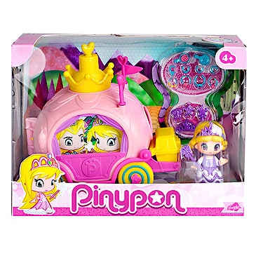 Boxed Pinypon toy set showing a pink princess carriage with a yellow crown, colourful wheels, and accessories. A small doll with a yellow hat and purple dress stands beside it. The packaging is mostly pink, with the Pinypon logo and recommended age 4+.