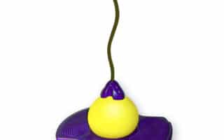 A yellow pogo ball toy with a purple circular platform in the centre, a handlebar at the top, and a cord connecting the handle to the ball, designed for jumping and balance activities.