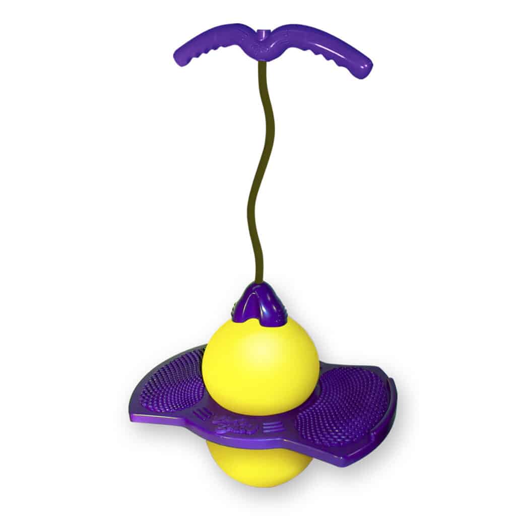 A Pogo Ball toy with a large yellow rubber ball sandwiched between two textured purple plastic foot platforms and a curved purple handle connected by a black cord. The toy is designed for bouncing and balancing.