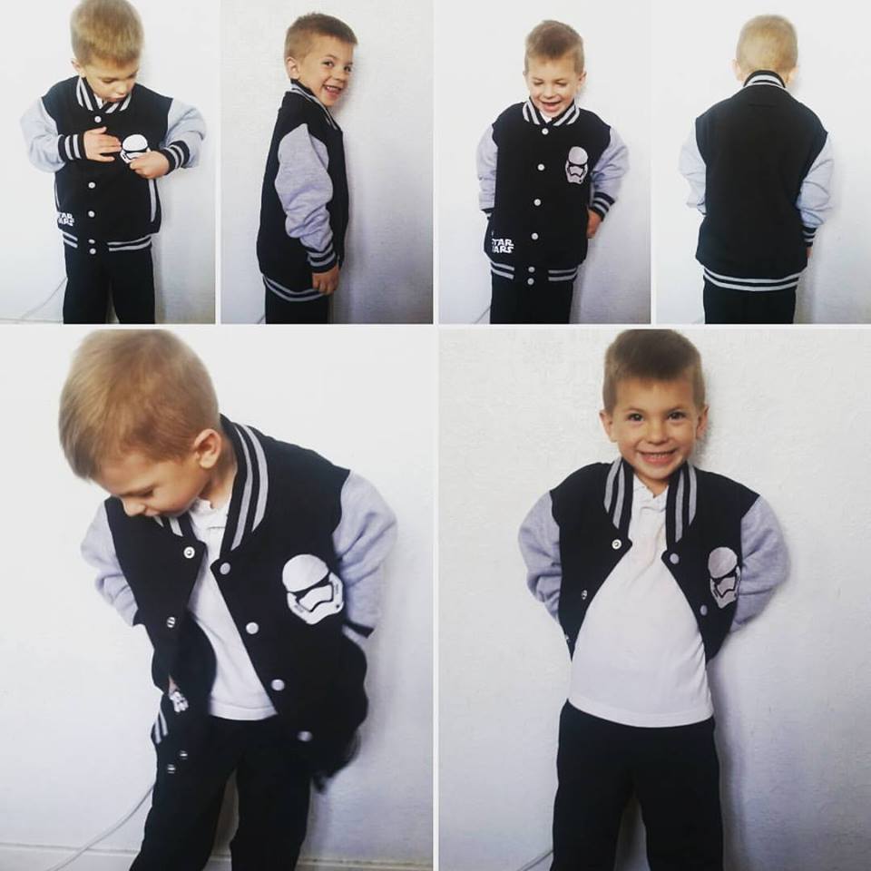 A young boy wearing a black and grey varsity jacket with a Stormtrooper logo, white shirt, and dark trousers poses in various ways: buttoning his jacket, smiling, turning sideways, facing backwards, looking down, and grinning at the camera.