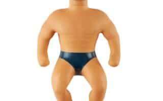 A toy figure with short blond hair, a muscular build, and a neutral expression. The figure is wearing only dark blue pants, has defined chest and arm muscles, and appears to be made of a flexible, rubbery material.