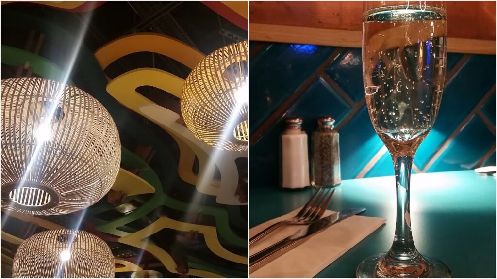 A split image: left shows rattan lamps and colourful wavy ceiling decor; right shows a glass of sparkling drink on a teal table with fork, knife, serviette, salt and pepper shakers, and blue tile wall in the background.