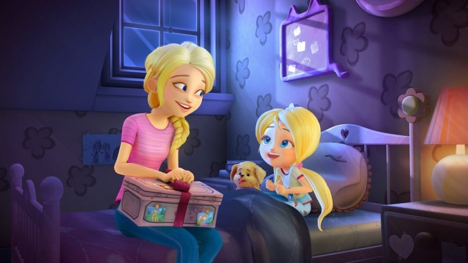 In a cosy, purple-themed bedroom, a woman with blonde hair in a plait smiles at a little blonde girl in pyjamas sitting on a bed with a puppy. The woman holds a decorated box. The room features heart-shaped wall patterns and a window showing a night sky.