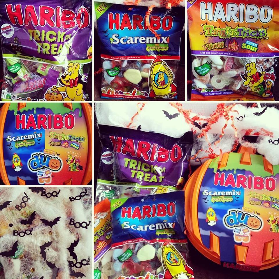 A collage of Halloween-themed Haribo sweet packs, including “Trick or Treat,” “Scaremix,” and “Tangfastricks.” The sweets are surrounded by fake cobwebs, plastic spiders, and Halloween decorations like “Boo!” text and bat shapes.
