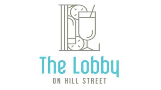 Minimalistic logo for “The Lobby on Hill Street.” The design features outlined snacks and a drink forming the shape of an uppercase "L." Below, “The Lobby” is written in large light blue letters; “ON HILL STREET” appears underneath in smaller grey text.