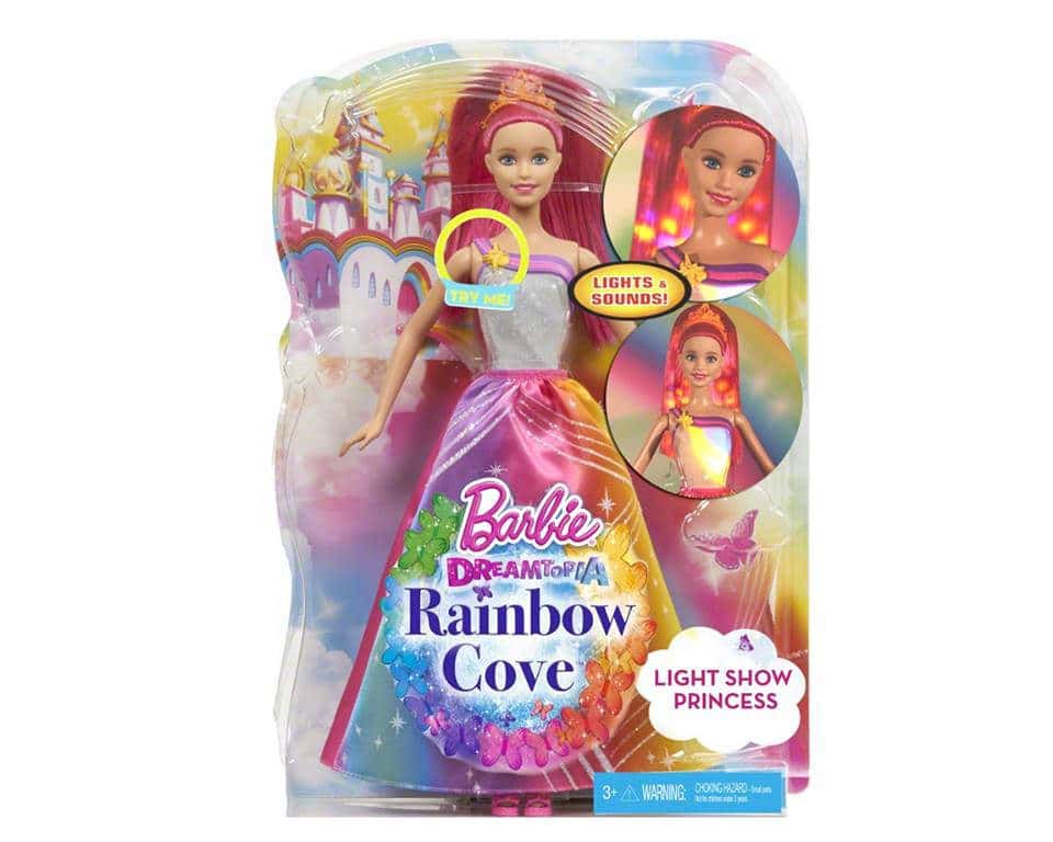 A Barbie Dreamtopia Rainbow Cove Light Show Princess doll in colourful packaging. The doll has long pink hair, a sparkling top, and a rainbow skirt that lights up. The box features bright rainbow and castle graphics and reads “Lights & Sounds!” and “Light Show Princess.”.