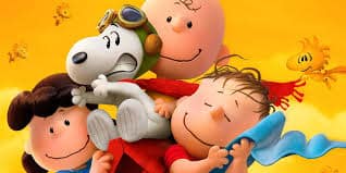 Lucy, Snoopy (wearing aviator goggles and a scarf), Charlie Brown, and Linus smile joyfully under a bright orange sky. Woodstock and other yellow birds fly in the background, adding to the cheerful scene from the Peanuts comic strip.