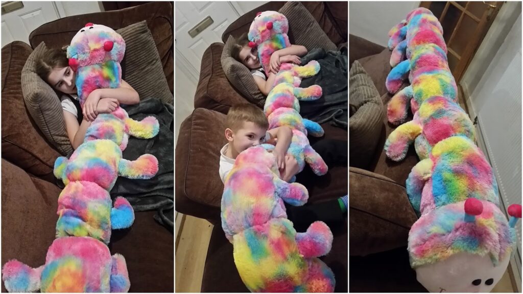 A child relaxes on a brown sofa, cuddling a long, rainbow-coloured plush caterpillar with red antennae. The caterpillar stretches from the child's arms down the length of the sofa. Three photos show different perspectives of the same scene.