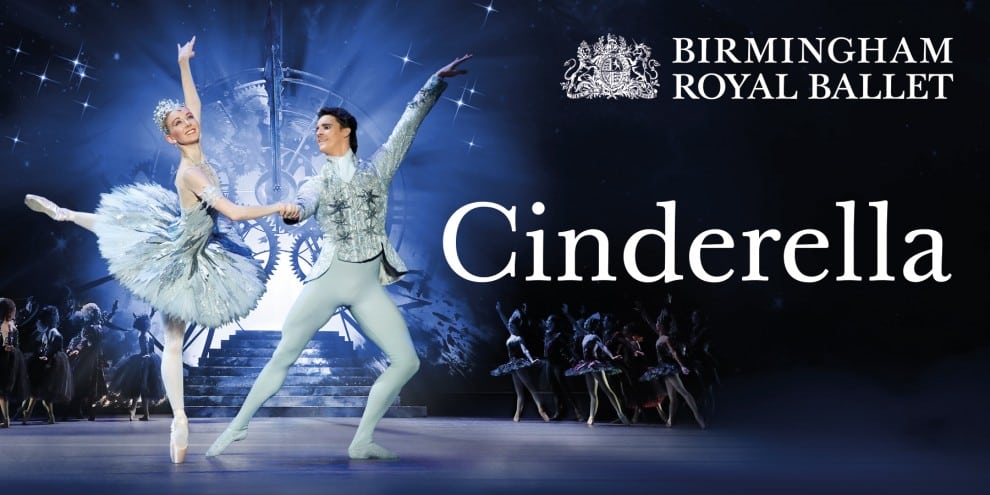 A ballerina in a pale blue tutu and a male dancer in light blue tights perform onstage before a backdrop of a large clock. Other dancers are visible in the background. The text reads: "Birmingham Royal Ballet Cinderella.