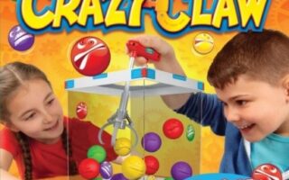 Two children smile and play the Crazy Claw arcade game, trying to grab colourful plastic balls with a claw inside a clear box. The background is bright with cartoon emoji faces and gears. Text reads, "Crazy Claw: The Crazy Arcade Action Game.