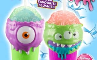 Two colourful slushy cups shaped like monster faces—one purple with one eye, the other green with two eyes and blue drool—sit on an icy blue background. Text reads: "Frozen Brain Slushy Maker," "Prepare your favourite slushies," and "Freeze, Squeeze and Enjoy!".