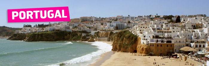 A coastal town in Portugal with white buildings clustered on cliffs above a sandy beach. The turquoise sea curves along the shore, and a pink "PORTUGAL" label is placed on the upper left side of the image.
