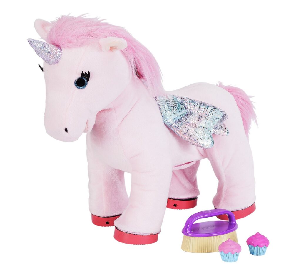 A plush pink unicorn toy with a sparkly horn, blue eyes, shiny silver wings, and pink mane and tail. In front of it are a purple-handled brush and two toy cupcakes with pink icing. The unicorn’s hooves are red.