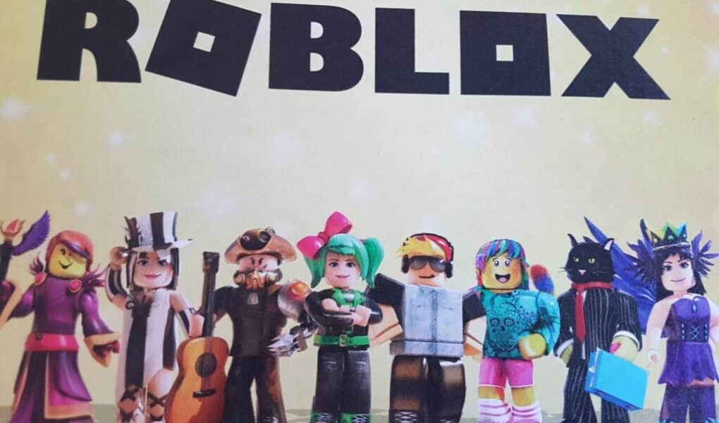 A row of eight colourful Roblox characters stands beneath the bold black "ROBLOX" logo on a yellow, starry background. Each character is dressed in unique outfits, including hats, headphones, fantasy costumes, and vibrant hairstyles.