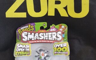 A ZURU-branded bag stands upright behind a packaged ZURU Smashers toy. The packaging features three ball-shaped collectables decorated as eyeballs and colourful cartoon graphics, with text promoting the toy series and collectable features.