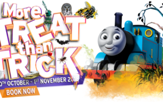 Colourful promo for a Halloween event with Thomas the Tank Engine and Emily. The text reads “More Treat than Trick” with spooky decorations and pumpkins. Dates listed are “20th October – 1st November 2018.” An orange "Book Now" button is at the bottom.