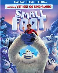 Blu-ray cover for "Smallfoot." A big, white yeti holds a smiling human man in red on its hand. Other yetis stand behind them on a snowy mountain. The title "SMALLFOOT" is in large white letters, and a banner above mentions a "Yeti Set Go Sing-Along.