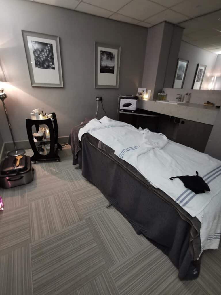 A massage room with a bed and a basin.