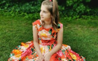 A girl sitting on grass.