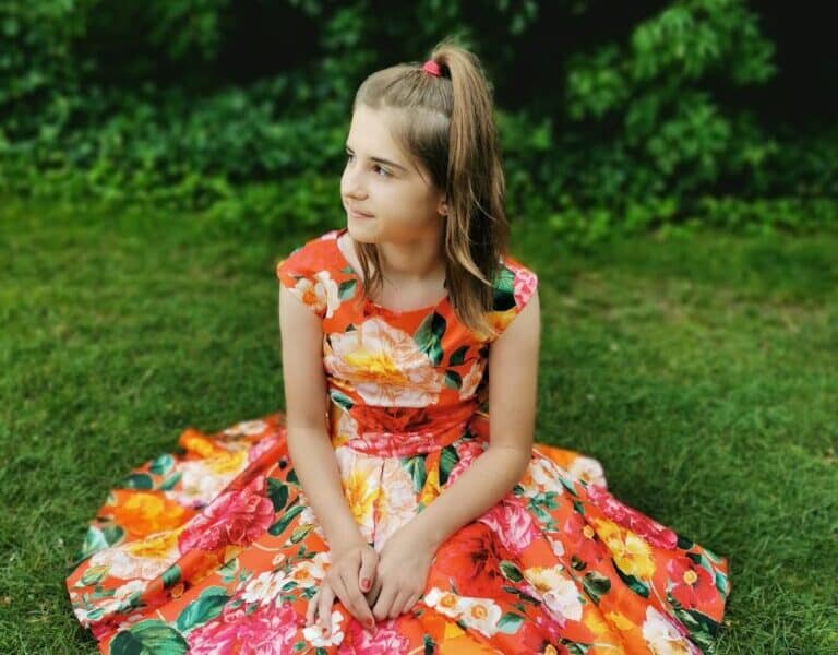 A girl sitting on grass.
