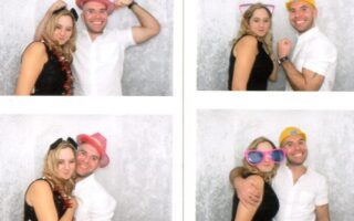 A photo booth strip features a smiling man and woman wearing fun hats and large pink glasses, posing playfully together against a light grey backdrop in various poses, including side-by-side, back-to-back, and with arms round each other.