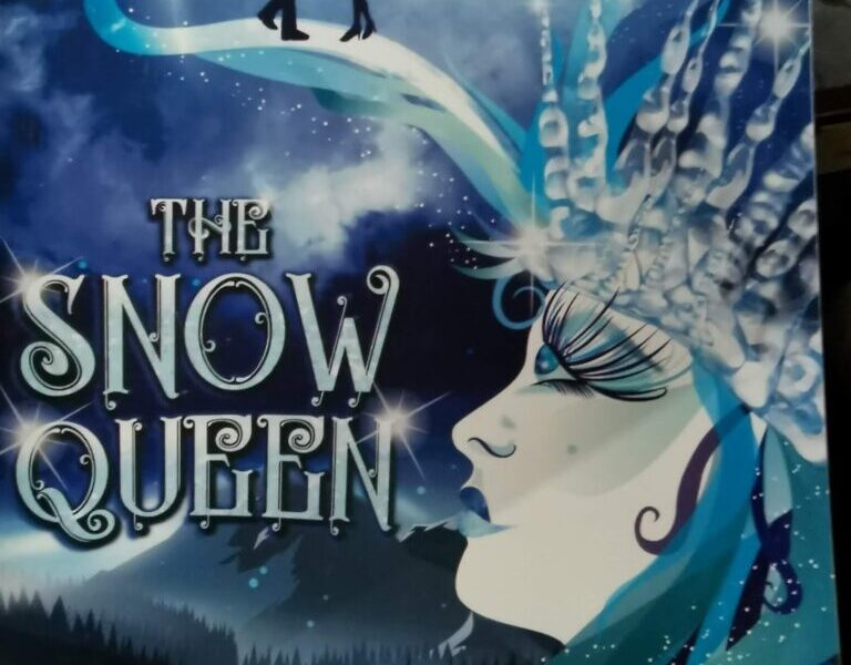 A theatre programme cover for "The Snow Queen" shows a profile of a white-faced woman with icy blue features and a crystal crown. Above her, two silhouetted figures stand on a curved icy path against a large moon and snowy sky.
