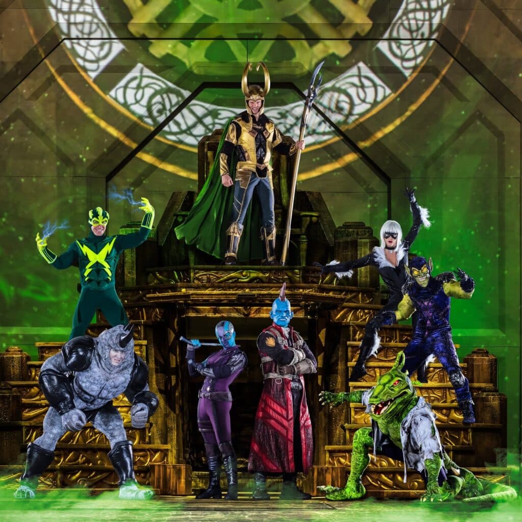 Eight Marvel villains in elaborate costumes pose on a golden, throne-like stage with green lighting and a mystical clock symbol in the background. Loki stands at the top holding a sceptre, surrounded by characters like Rhino, Nebula, Yondu, and others.