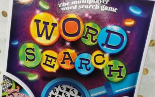 A board game box titled “Word Search” features colourful, bubble-like letters on a purple background with glowing circles. The tagline reads “The multiplayer word search game.” Icons at the bottom indicate recommended age and number of players.