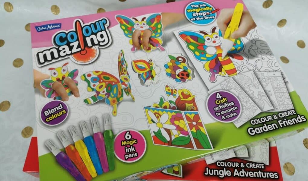 A “Colourmazing” craft kit box features colourful butterflies and animals, paint pens, and completed craft samples. The label highlights “Blend colours,” “6 magic ink pens,” “4 crafts to decorate & display,” and “Colour & Create Garden Friends.”.