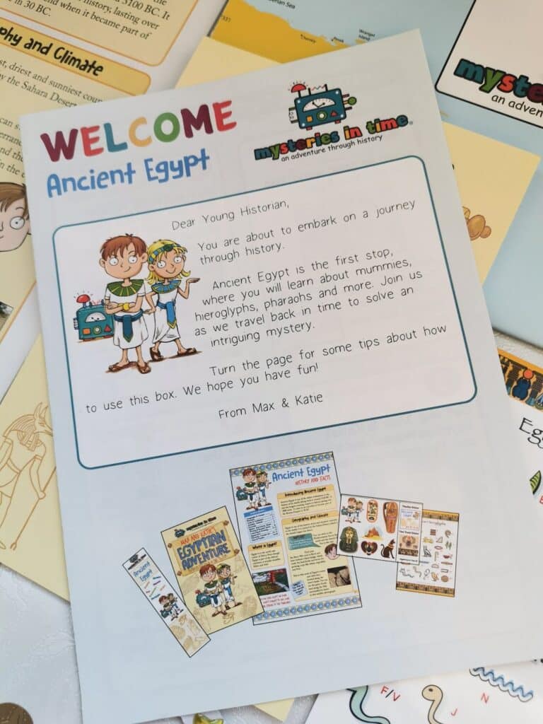A colourful welcome letter titled "Ancient Egypt" features cartoon children and a cute robot. The text invites young historians on a journey through history, mentioning hieroglyphs, pharaohs, and mummies. Illustrated history materials and booklets are visible beneath.