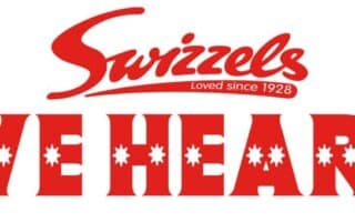 The image features the red "Swizzels" logo with the slogan "Loved since 1928" above bold red text reading "LOVE HEARTS." Each letter "O" in "LOVE" and "HEARTS" contains a white heart shape in the centre. The background is white.