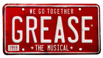 A red, vintage-style number plate with white text that reads, "WE GO TOGETHER GREASE THE MUSICAL." In the bottom left corner, there is a small rectangle with "1959" inside it. The overall design promotes the musical "Grease.