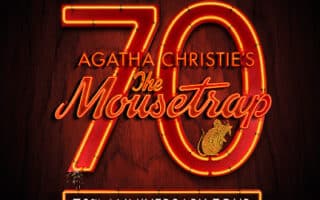 A poster with glowing red and orange text reads: "Have YOU dunnit? 70 Agatha Christie's The Mousetrap 70th Anniversary Tour." The number 70 and "The Mousetrap" are in neon-style script, with a small mouse illustration on the "p.