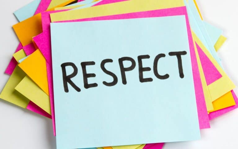 A stack of colourful sticky notes, with a blue note on top displaying the word "RESPECT" written in bold, black letters. The notes beneath are pink, yellow, and orange, creating a vibrant and positive background.